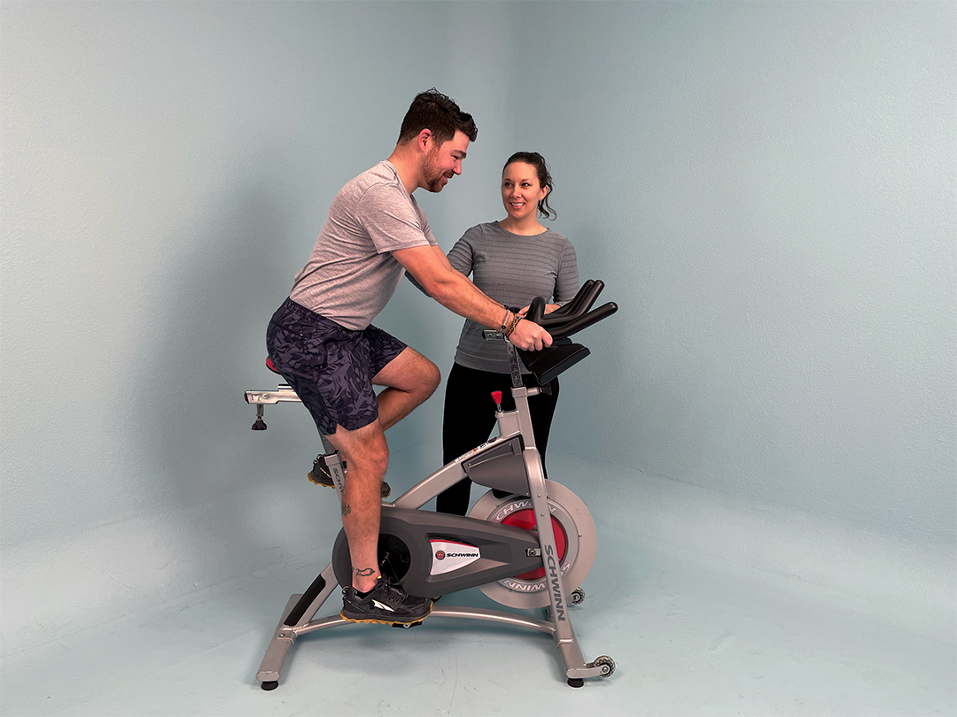 Angie trains Kyle on an exercise bike.
