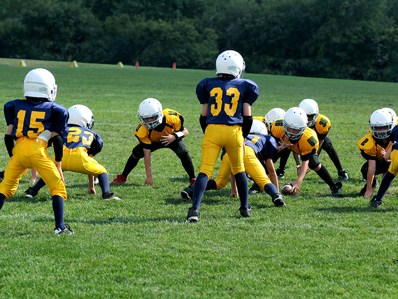 Children play football on a field. 