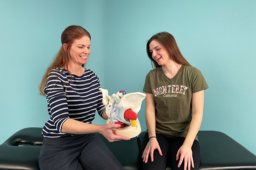 Kristen Branham shows a female patient a pelvic floor model. 