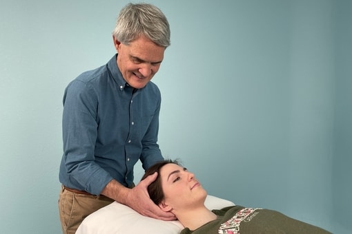 Tim treats a patient's head. 